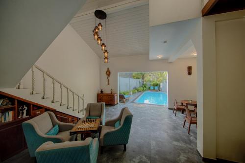 a living room with a pool in the background at Deltora Villa - free drop off to Galle Fort by TukTuk in Galle