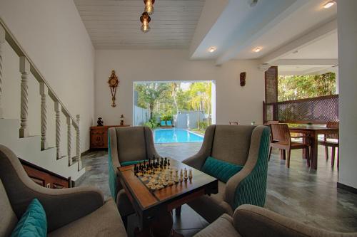 a living room with a table and chairs and a pool at Deltora Villa - free drop off to Galle Fort by TukTuk in Galle