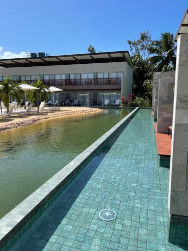 a swimming pool in front of a building at Flat Deluxe no centro de Pipa in Pipa