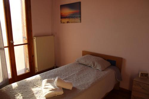 Un dormitorio con una cama con una toalla encima. en Komninos' Traditional House, en Artemida