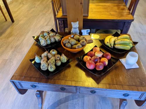 a table with plates of fruit and a bowl of bananas at Pazo de Chaioso Ribeira Sacra in Maceda