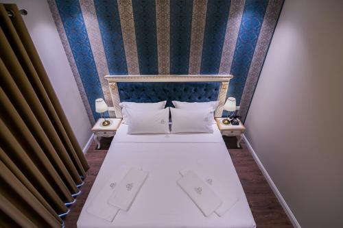 a hotel room with a bed with two pillows at Legacy Boutique Hotel in Korçë