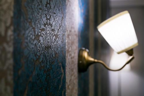 a lamp is attached to a wall at Legacy Boutique Hotel in Korçë