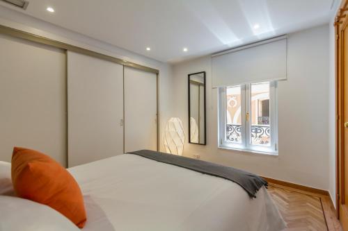 1 dormitorio con cama blanca y ventana en Homelike Sol - Gran Via I, en Madrid