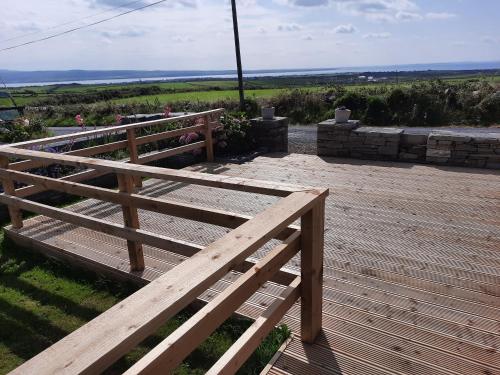 a wooden bench sitting on top of a wooden deck at BallyV House in Liscannor