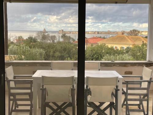a table and chairs on a balcony with a view at Bay View Villas in Methoni