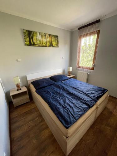 um quarto com uma cama com um cobertor azul em Levi's wellness apartman em Siófok