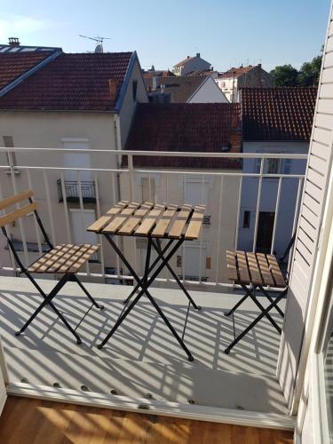 two chairs and a picnic table on a balcony at Appartement à 5 minutes à pied du centre équestre du Sichon in Vichy