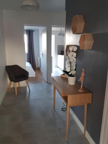 un salon avec un bureau et une chaise dans l'établissement Appartement à 5 minutes à pied du centre équestre du Sichon, à Vichy