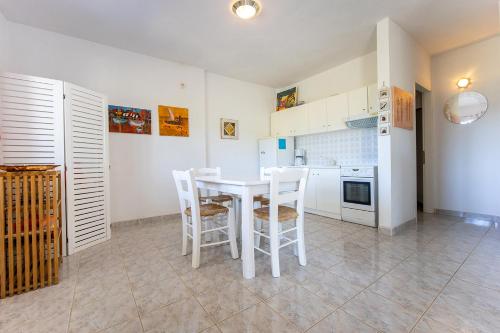 a kitchen with a white table and chairs at Dimitra Beach Apartments - Thassos Skala Potamias in Skala Potamias