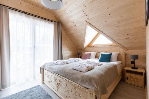 a bedroom with a bed with towels on it at Osada Chłabówka Zakopane & SPA in Zakopane