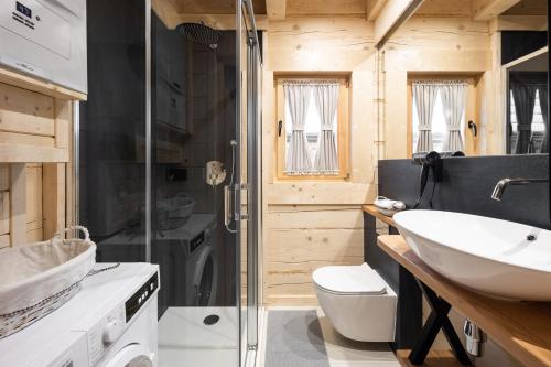 a bathroom with a sink and a toilet and a shower at Osada Chłabówka Zakopane & SPA in Zakopane