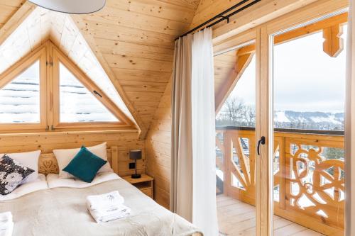 a bedroom with a bed in a wooden house at Osada Chłabówka Zakopane & SPA in Zakopane