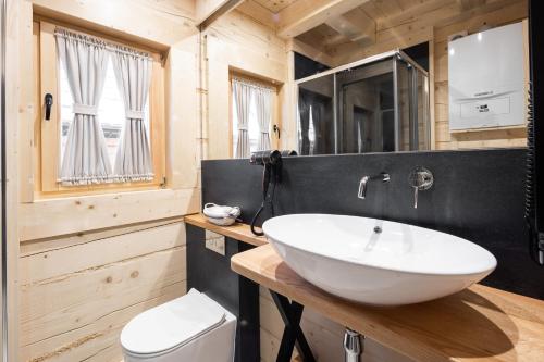 a bathroom with a white sink and a toilet at Osada Chłabówka Zakopane & SPA in Zakopane