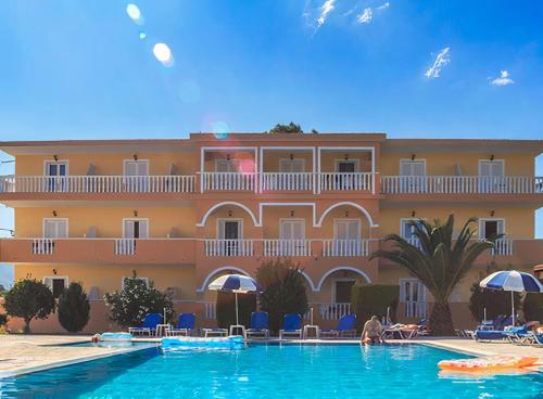 a hotel with a swimming pool in front of a building at Derekas studios & apartments in Laganas