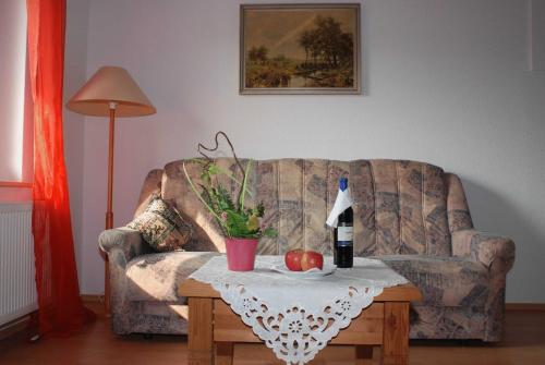 ein Wohnzimmer mit einem Sofa und einem Tisch mit einer Flasche Wein in der Unterkunft Ferienwohnung Pferdezentrum Edersee in Waldeck