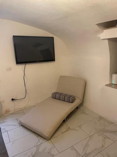 a couch with a flat screen tv on a wall at Mory&Clary Cave Palese Airport in Bari Palese