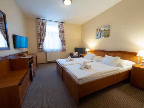VillánykövesdにあるHotel Cabernetの大きなベッドとデスクが備わるホテルルームです。