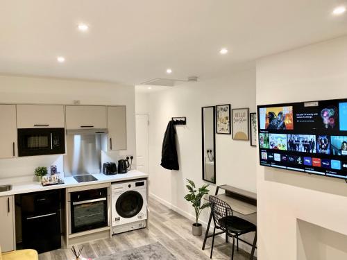 una cucina con lavatrice e asciugatrice in camera di Beautiful Studio apartment in a house with parking a Erith