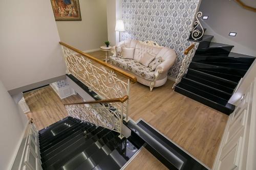 a stairway with a chair and a couch at Legacy Boutique Hotel in Korçë