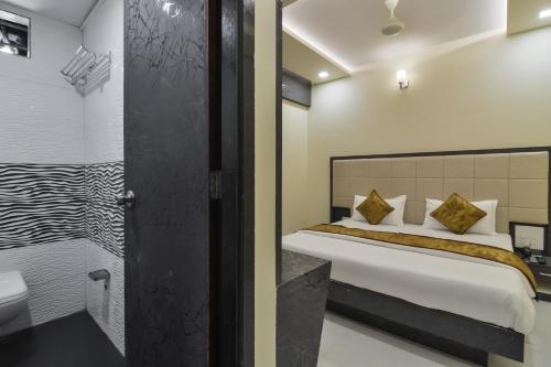 a bedroom with a bed and a bathroom at Hotel Aroma- Dadar in Mumbai