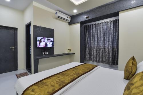 a bedroom with two beds and a tv at Hotel Aroma- Dadar in Mumbai