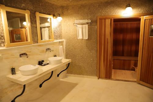 a bathroom with two sinks and a mirror at Roma Cave Suite in Goreme