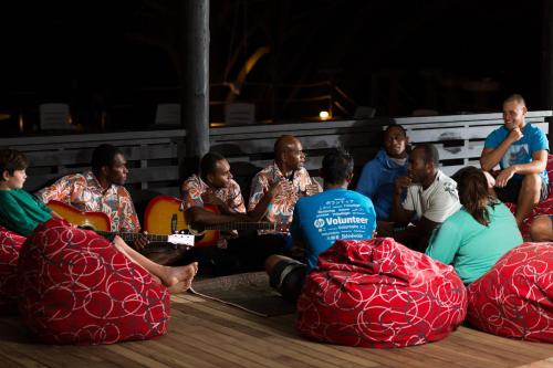 a group of people sitting on the floor playing guitar at Funky Fish Beach & Surf Resort in Malolo
