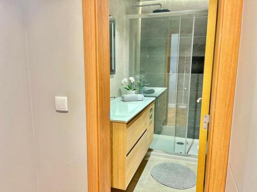 a bathroom with a sink and a shower at T2 com uma vista deslumbrante sobre o Atlântico! in Costa da Caparica