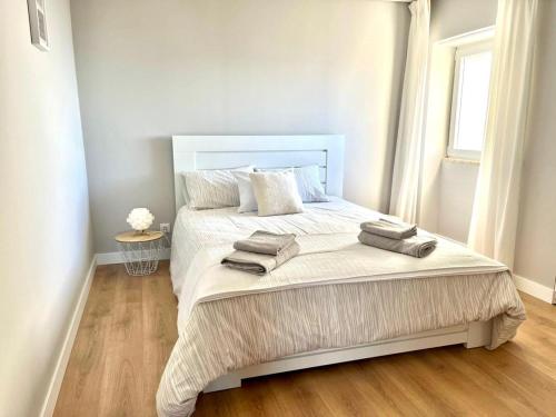 a bedroom with a large bed with two towels on it at T2 com uma vista deslumbrante sobre o Atlântico! in Costa da Caparica
