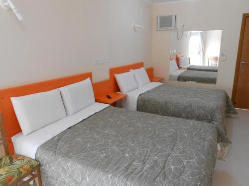 a hotel room with two beds in a room at Hotel Canto da Riviera in Riviera de São Lourenço