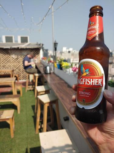 a person holding a bottle of beer on a bar at Sprinklers in New Delhi