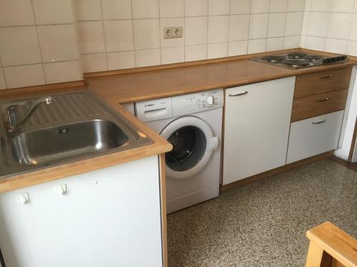 a kitchen with a sink and a washing machine at Hotel Adria in Bolzano