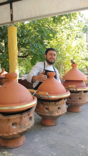 a man wearing an apron standing next to fire hydrants at Toubkal Ecolodge in Imlil