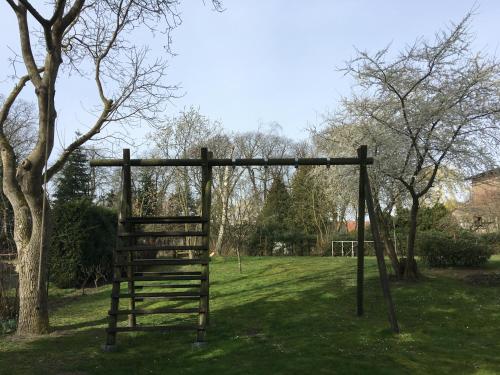 a wooden swing set in a field with trees at Ferienwohnung Kastanienblick oder Parkblick, oder unser Radlerzimmer! in Ziethen
