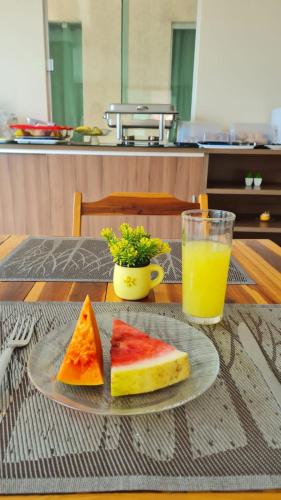 a plate with two slices of bread and a glass of orange juice at Hotel Camocim in Camocim
