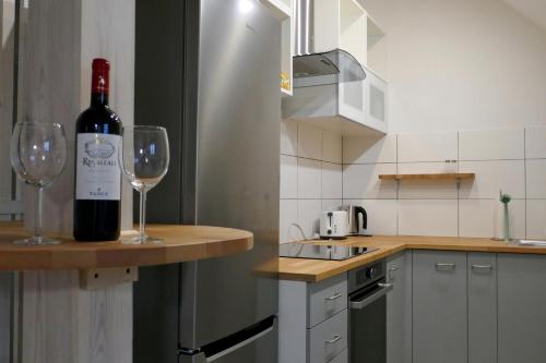 a bottle of wine sitting on a counter with two wine glasses at Rezydencja Masuria in Siemiany