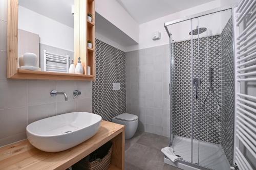 a bathroom with a white sink and a shower at Il Fouia Apartments in Pragelato