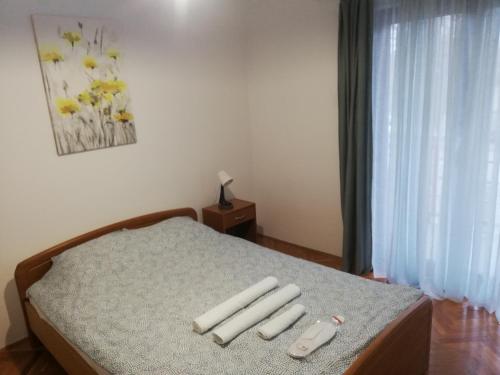 a bedroom with a bed with four remote controls on it at Apartments Mateo in Zagreb