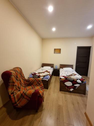 a room with two beds and a chair in it at Shorena & Nino in Stepantsminda