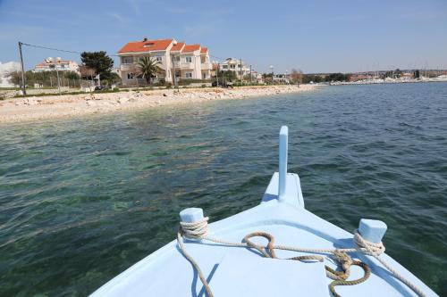 a boat in the water next to a beach at Villa Punta in Zadar