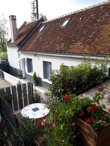 a white house with a table and some flowers at gite de la tour carrée in Montrichard