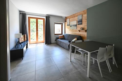 een woonkamer met een tafel en een bank bij Il Fouia Apartments in Pragelato