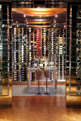 a wine cellar with a table in front of a wall of wine bottles at The Langham Huntington, Pasadena in Pasadena
