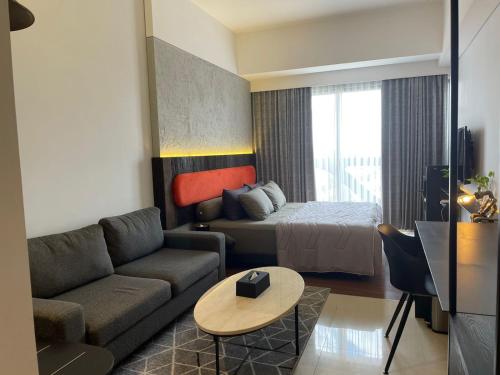 una sala de estar con un sofá y una cama en Ruby Apartment #5, en Kejayan