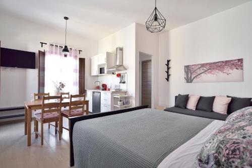 a bedroom with a bed and a table and a kitchen at Family Rooms Scicli Centro in Scicli
