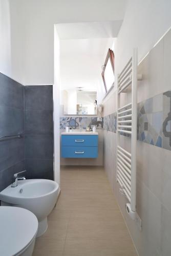 a bathroom with a white toilet and a sink at Family Rooms Scicli Centro in Scicli