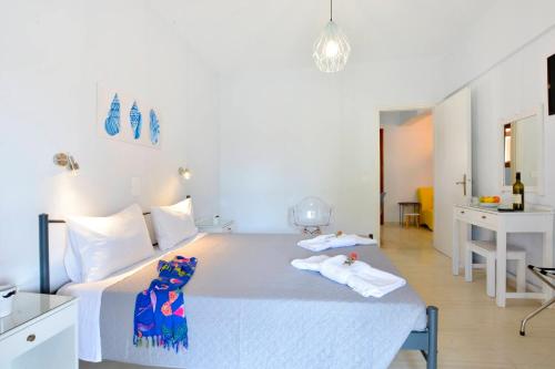a white bedroom with a bed and a bathroom at Kalliopi Apartments in Roda