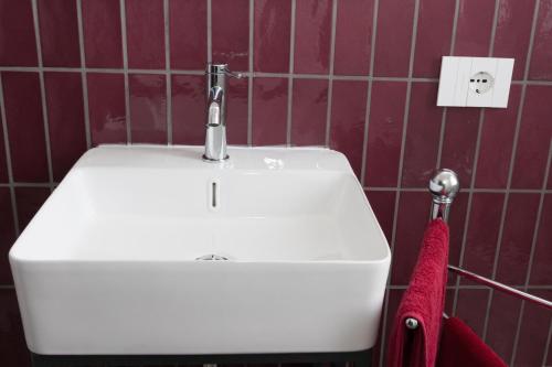a bathroom with a white sink and a red towel at la Brunita in Rubiera