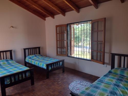 a room with two beds and a window at La Churrasquita in Salsipuedes